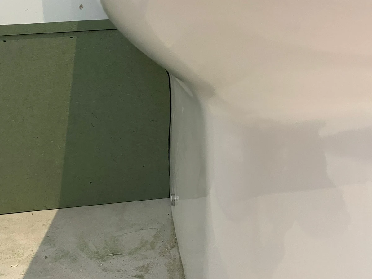 Bathroom fitting in progress with toilet pan against green board before tiling in Swansea