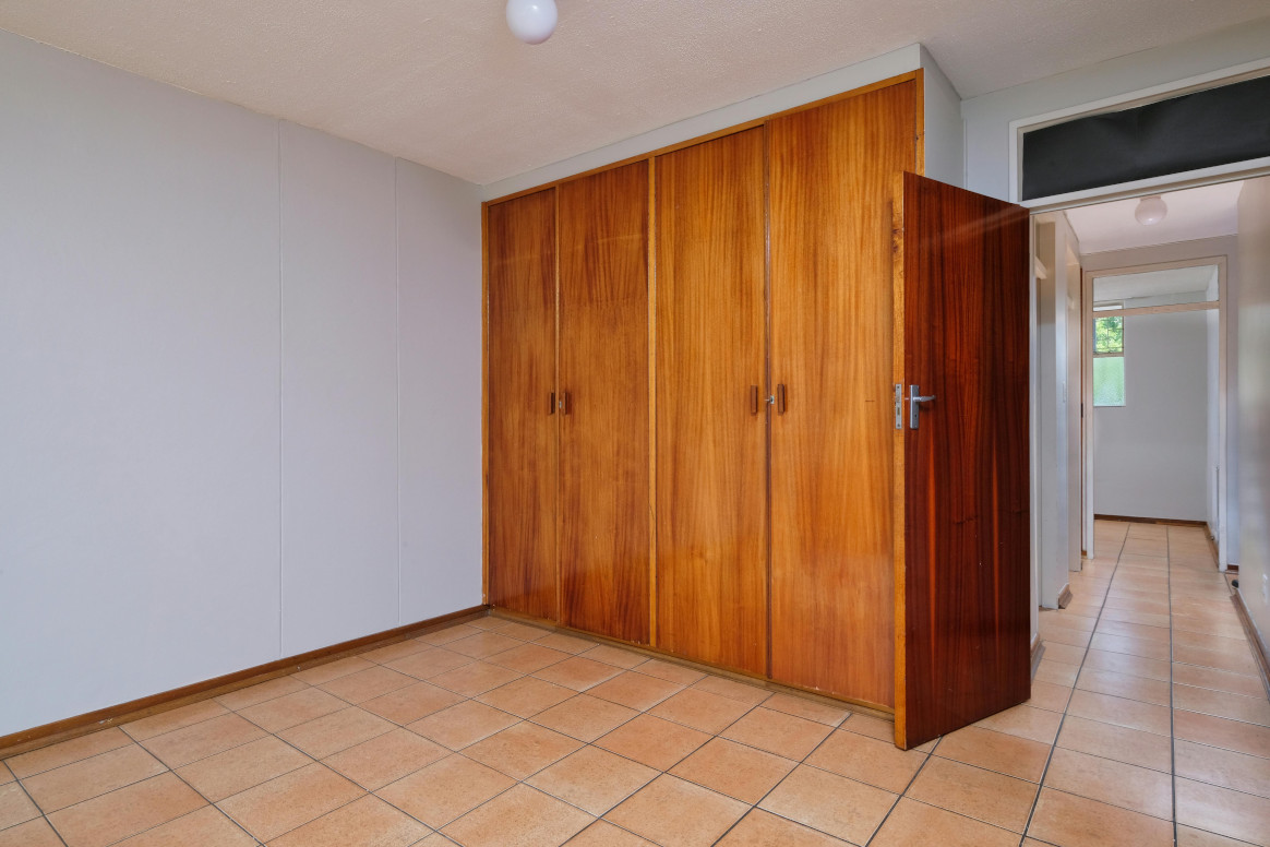 Timber-fronted fitted wardrobes Timber-fronted fitted wardrobes filling a bedroom wall