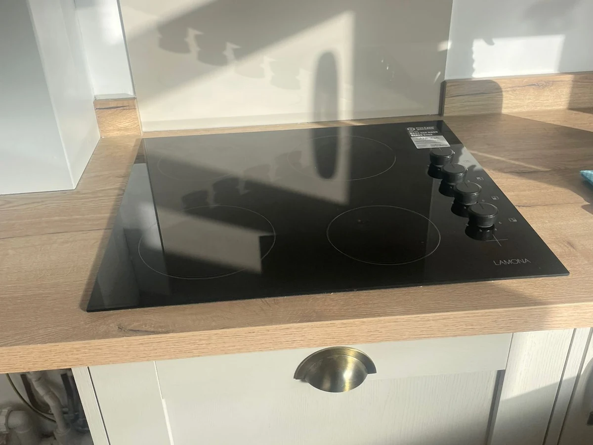 kitchen-fitting-induction-hob-glass-splashback-oak-worktop-swansea-daffodil-carpentry Kitchen countertop with new hob and cabinet. By Daffodil Carpentry, local kitchen fitters in Clydach.