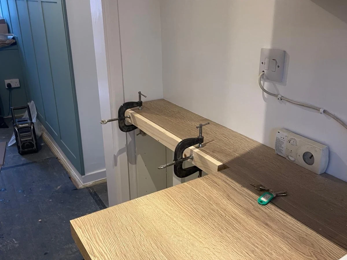 Timber worktop held with clamps during fitting