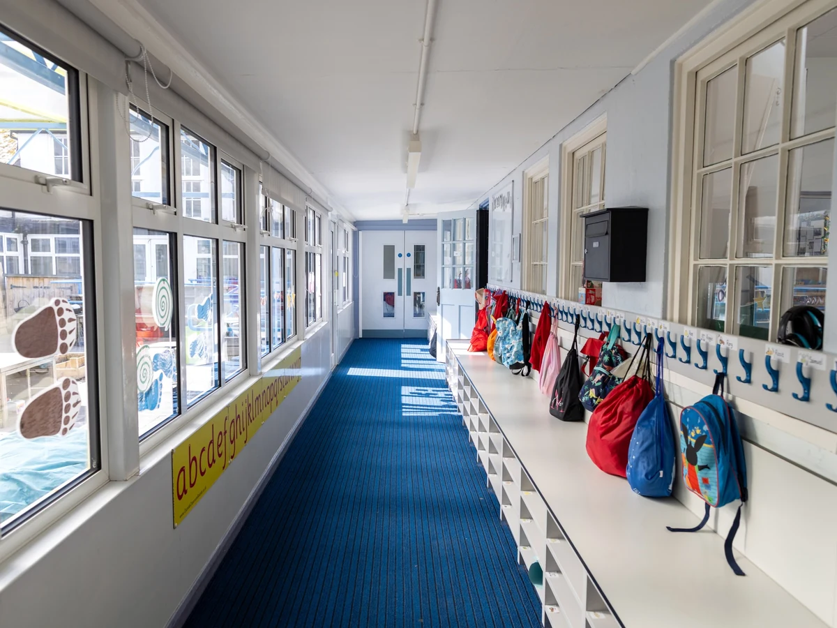 school-corridor-commercial-premises-daffodil-carpentry Bright school corridor with coat hooks and blue carpet