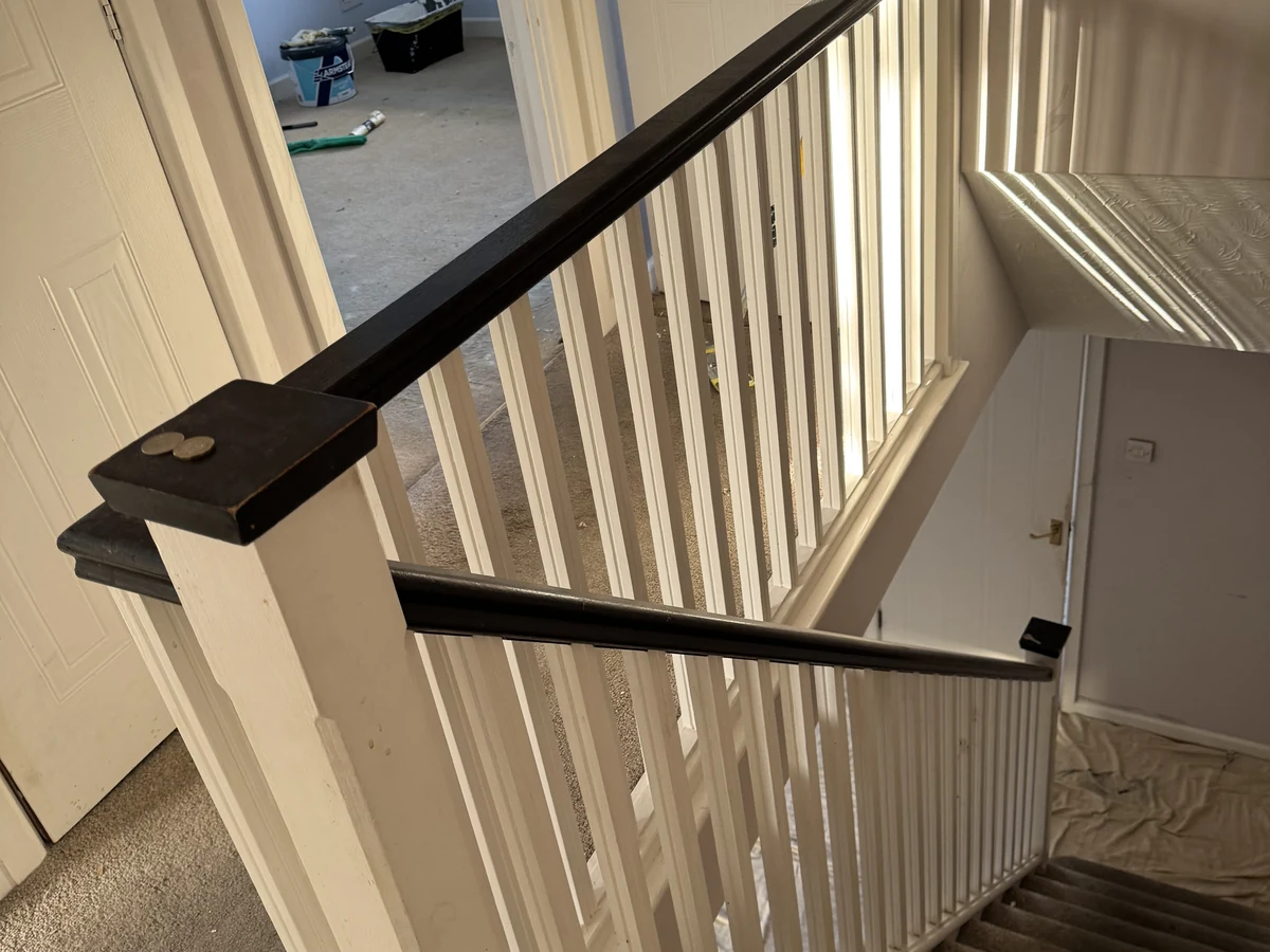 Renovated staircase with white spindles and black handrail newel post in Swansea by Daffodil Carpentry