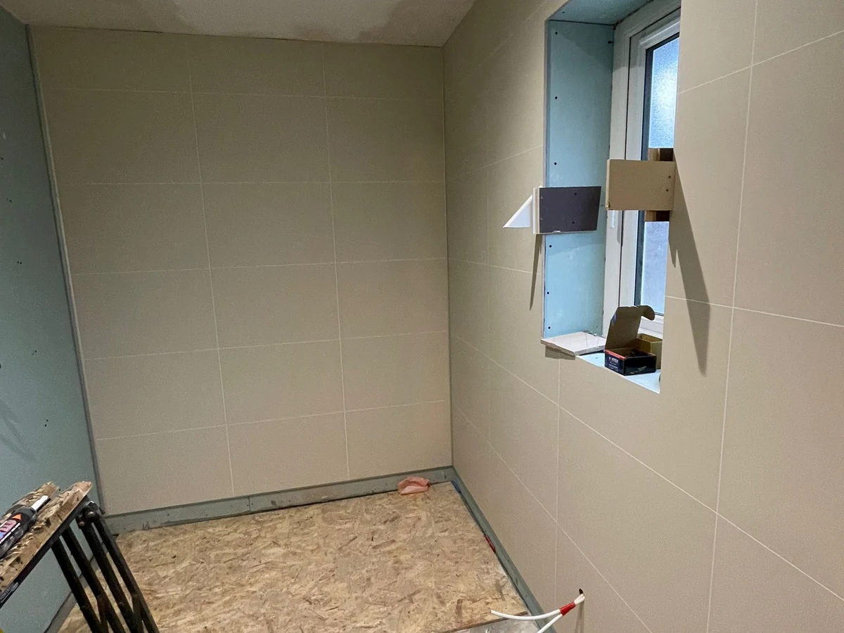 Beige tiles in completed wetroom with window recess in Swansea by Daffodil Carpentry