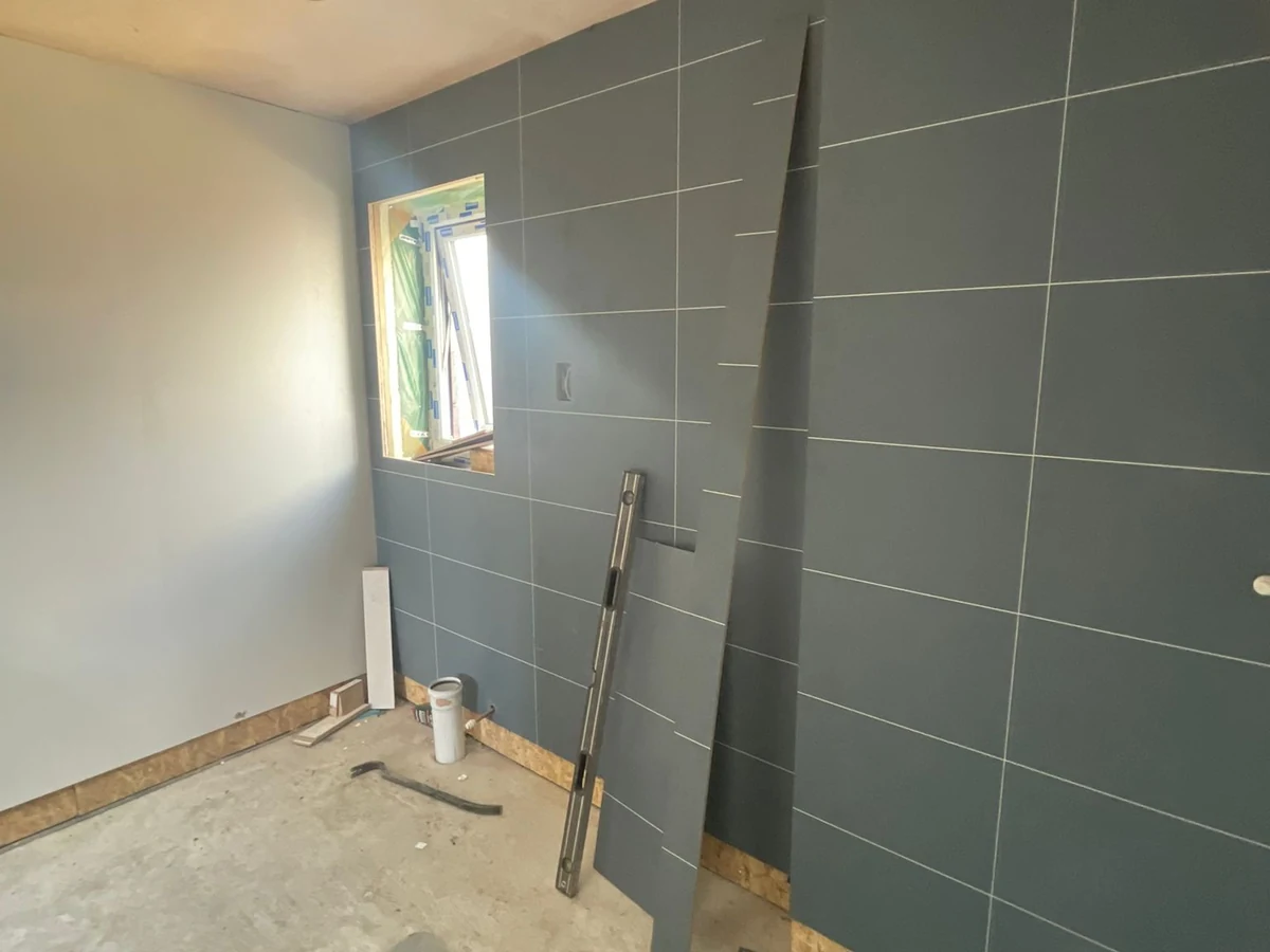 tiling-dark-blue-large-format-tiles-mid-installation-swansea-daffodil-carpentry Dark blue large format tiles mid-installation during shower tiling in Swansea