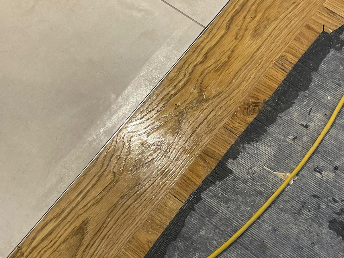 Oak floor to tile transition with laser level line during renovation in Swansea by Daffodil Carpentry